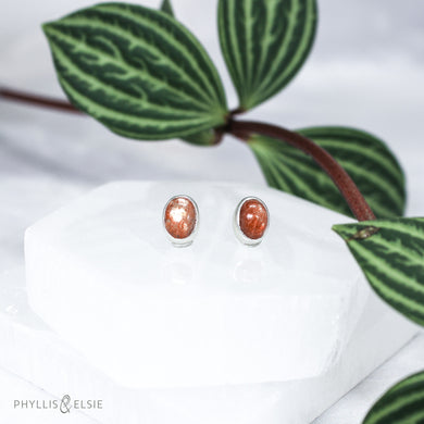 These Sunstone earrings are ﻿simple and sweet but not shy with their beautiful shimmery reddish-orange hue!  Details:  Solid sterling silver, partially recycled  Sunstone  Earring faces: 9mm x 7mm  Surgical Steel butterfly backings
