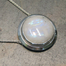 Load image into Gallery viewer, A fitting homage to the elegant and mysterious moon goddess Diana, this medallion style necklace features a weighty and luminous Moonstone cabochon bezel set and ringed with a wide band of solid silver. A sleek chain mounted directly to the edges of the pendant gives a clean finish and keeps the pendant centered.  A 16” chain ensures the pendant will lay comfortably just below your collarbones.
