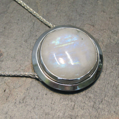 A fitting homage to the elegant and mysterious moon goddess Diana, this medallion style necklace features a weighty and luminous Moonstone cabochon bezel set and ringed with a wide band of solid silver. A sleek chain mounted directly to the edges of the pendant gives a clean finish and keeps the pendant centered.  A 16” chain ensures the pendant will lay comfortably just below your collarbones.