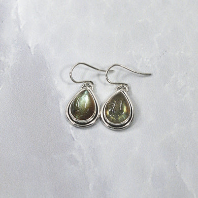 A perfect match for the Stella Classic necklace, these dangly drop earrings of mossy green labradorite are wrapped snugly with a banded bezel and swing freely to catch the light.