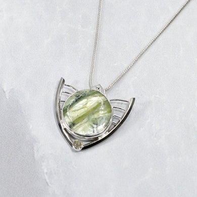 Faye features delicate handcrafted wings to frame this necklace’s substantial eye-catching Green Opal. A beautiful spring green, the stone is striped with shimmering bands and accented by a tiny drop of yellow-green labradorite.