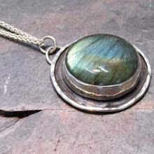 Load image into Gallery viewer, This Jaida necklace has an earthy, organic feel with its blue-green Labradorite centered in an antiqued shadowbox framed by a hand-textured halo. The sleek silver wheat chain lets the pendant steal the show while still providing elegance and strength.
