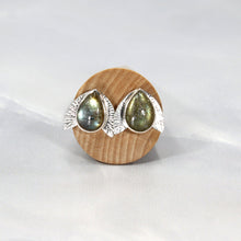 Load image into Gallery viewer, This playful pair of stud earrings features large glowing green Labradorite teardop cabochons flanked by hand-textured silver wings.  
