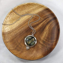 Load image into Gallery viewer, This gorgeous Valarie necklace will be the center of your outfit. A large deep green labradorite with flashy golden stripes is surrounded by a peaked ring of silver and accented by a tiny labradorite set on a hand-textured backer. Delicately hand-cut vine patterns on the back give this piece an extra custom feel.
