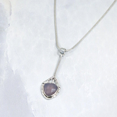 Eloise is a charming y-shaped necklace with a lovely faceted Lilac Chalcedony. Hand carved texture balances out the geometric shapes framing the stone.