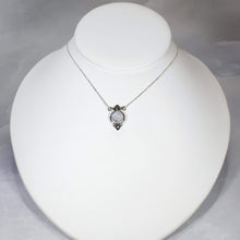 Load image into Gallery viewer, Hand-shaped silver tendrils allow this Fleur pendant to glide along its dainty oval chain. A narrow round bezel band and silver pebbles accent the violet-blue flash of the Moonstone.
