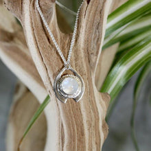 Load image into Gallery viewer, One part portal and one part shield talisman, this aqua blue Labradorite Deidra is all sleek elegance and high shine.     Details:  Solid sterling silver, partially recycled  Natural Labradorite cabochon  Pendant: 30 x 27mm  18” long Sterling Silver chain plus 2” Extender  Handmade s-hook clasp

