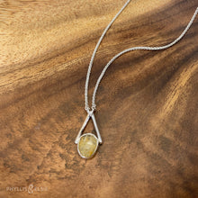 Load image into Gallery viewer, Rosecut Quartz with golden hued crystalline inclusions set in a silver bezel and suspended in an airy frame  Details:  Solid sterling silver, partially recycled  Rutilated Quartz  Pendant: 13mm x 26mm 16” long Sterling Silver chain plus 2” Extender  Lobster-claw clasp
