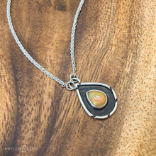 Load image into Gallery viewer, A brilliant orange and green teardrop opal is accented by a wide shadowbox and a delicately detailed border.  Solid sterling silver, some recycled content  Ethiopian Opal cabochon  Pendant 13mm x 21mm  17” long Sterling Silver chain with 2&quot; extender
