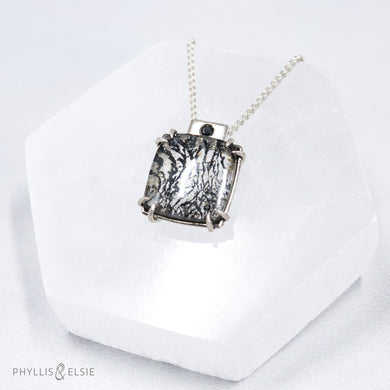 A glamorous Dendritic Quartz held by 8 tapered prongs is capped with a flush set Black Spinel and slides on a sleek silver wheat chain  Details  Solid sterling silver, partially recycled  Dendritic Quartz, Black Spinel  Pendant: 17mm x 22mm  16