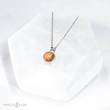 Load image into Gallery viewer, This 9mm Luna necklace features a beautiful orange Ethiopian Opal set simply in a smooth silver bezel. A a diamond cut chain adds a subtle sparkle to complete the clean, classic look you will find yourself wearing over and over.  Details  Solid sterling silver, partially recycled  Ethiopian Opal  Pendant: 9mm  16” long Sterling Silver chain   Lobster-claw clasp
