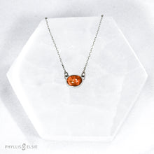 Load image into Gallery viewer, Evie brings the perfect tiny highlight to your look. The lovely Ethiopian Opal shows flashes of hot pink, orange, and green in a soft orange base. It and is nestled in a delicate diamond-cut sterling silver chain for extra sparkle.  Details  Solid sterling silver, partially recycled  Ethiopian Opal   Pendant 10mm X 6mm  16” long Sterling Silver chain  Lobster claw clasp
