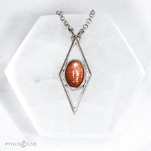 Load image into Gallery viewer, A rich orange oval Sunstone is centered in a diamond frame of polished silver. Beveled edges catch the light and highlight the stone floating in the center.  Details  Solid sterling silver, partially recycled  Sunstone  Pendant: 17mm x 41mm  18&quot; Sterling chain plus 2&quot; extension   Lobster claw clasp
