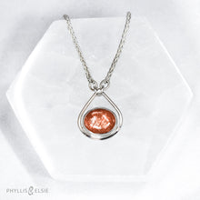 Load image into Gallery viewer, A shimmering orange Sunstone set in a silver bezel and nestled in an elegant and minimalist teardrop halo.   Details  Solid sterling silver, partially recycled  Sunstone  Pendant 17mm x 20mm  16” long Sterling Silver chain plus 2&quot; Extension  Lobster claw clasp
