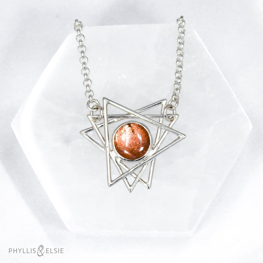 A big shimmering Sunstone cabochon sits nestled in the center of an openwork array of silver points. This necklace pairs beautifully with the Kasey earrings.   Details  Solid sterling silver, partially recycled  Sunstone  Pendant: 30mm x 28mm  17