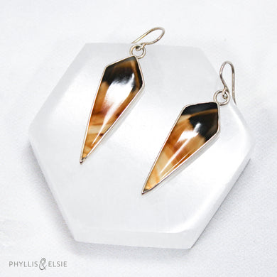 Bold and beautiful matching slices of Montana Agate set in sterling silver bezels with open backs to let the sun shine through.   Details:  Solid sterling silver, partially recycled  Montana Agate  Earring faces: 14mm x 40mm  Sterling silver ear hooks