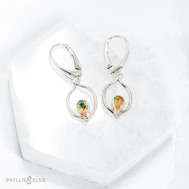 Dainty dangles with set with faceted Ethiopian opals suspended in a sterling frame. The faceted teardrop opals have stunning flashes of orange, yellow, and green depending on the light. Elegant lever-back ear hooks keep your new earrings secure with extra style.  Solid Sterling Silver, partially recycled  Natural Ethiopian Opals  Earring face - 12mm x 18mm  Sterling Lever-back ear hooks   