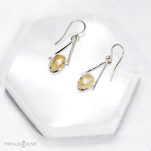 Load image into Gallery viewer, Rosecut Quartz with golden hued crystalline inclusions are suspended in an airy, asymmetrical frame  Details:  Solid sterling silver, partially recycled  Rutilated Quartz  Earring faces: 11mm x 23mm  Sterling silver ear hooks

