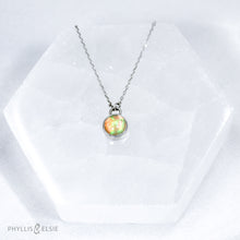 Load image into Gallery viewer, This 8mm Luna necklace features a beautiful Ethiopian Opal set simply in a smooth silver bezel. A a diamond cut chain adds a subtle sparkle to complete the clean, classic look you will find yourself wearing over and over.  Details:  Solid sterling silver, partially recycled  Ethiopian Opal  Pendant: 8mm  16” long Sterling Silver chain   Lobster-claw clasp
