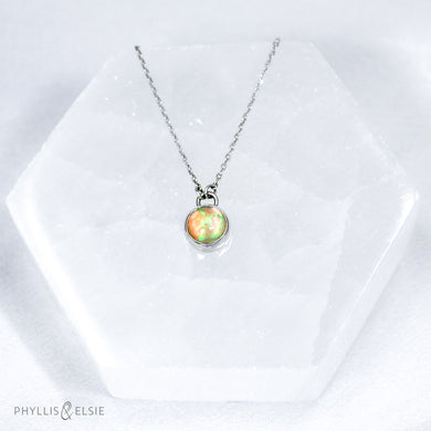 This 8mm Luna necklace features a beautiful Ethiopian Opal set simply in a smooth silver bezel. A a diamond cut chain adds a subtle sparkle to complete the clean, classic look you will find yourself wearing over and over.  Details:  Solid sterling silver, partially recycled  Ethiopian Opal  Pendant: 8mm  16” long Sterling Silver chain   Lobster-claw clasp
