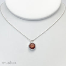 Load image into Gallery viewer, This 10mm Luna necklace features a beautiful rust colored Sunstone set simply in a smooth silver bezel. A slim oval chain completes the clean, classic look you will find yourself wearing over and over.  Details:  Solid sterling silver, partially recycled  Sunstone  Pendant: 10mm  16” long Sterling Silver chain   Lobster-claw clasp
