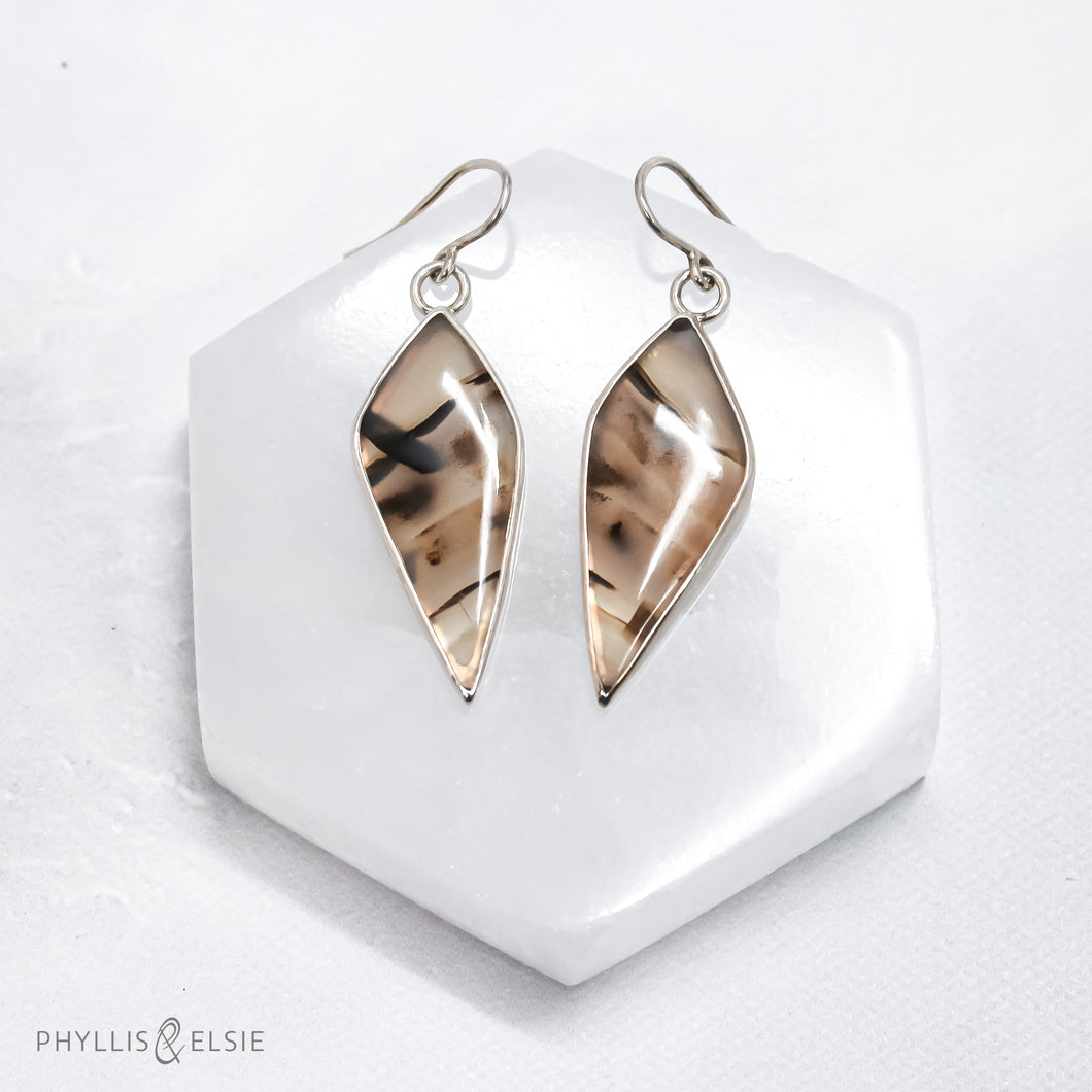 Bold and beautiful matching slices of Montana Agate set in sterling silver bezels with open backs to let the sun shine through.   Details:  Solid sterling silver, partially recycled  Montana Agate  Earring faces: 15mm x 38mm  Sterling silver ear hooks
