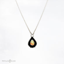 Load image into Gallery viewer, A brilliant orange and green teardrop opal is accented by a wide shadowbox and a delicately detailed border.  Details  Solid sterling silver, some recycled content  Ethiopian Opal cabochon  Pendant 13mm x 21mm  17” long Sterling Silver chain with 2&quot; extender

