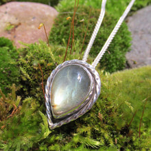 Load image into Gallery viewer, This Stella necklace features a glowing, smooth sage-green Labradorite teardop cabochon that shows glimpses of peach and aqua in bright light. Surrounded with a slightly-offset twisted halo, this pendant stands out despite its small size and soft colors.
