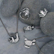 Load image into Gallery viewer, This snuggly silver Sea Otter curls his paws and tail around you finger in a tiny hug!   We donate a portion of all WildWhere sales to support continuing wildlife conservation efforts! Also shown: grizzly bear, sea turtle, tree frog, and sloth jewelry.
