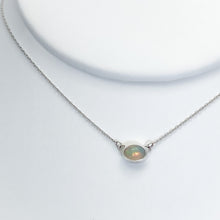 Load image into Gallery viewer, Evie brings the perfect tiny highlight to your look. The lovely Ethiopian Opal shows flashes of peach, green, and yellow and is nestled in a delicate diamond-cut sterling silver chain for extra sparkle. Solid sterling silver, partially recycled  Ethiopian Opal   Pendant 10mm X 6mm  16” long Sterling Silver chain  Lobster claw clasp
